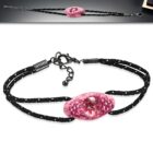 Fekete-fehér színű szövet karkötő, ovális alakú, virág mintás üveggyöngy dísszel